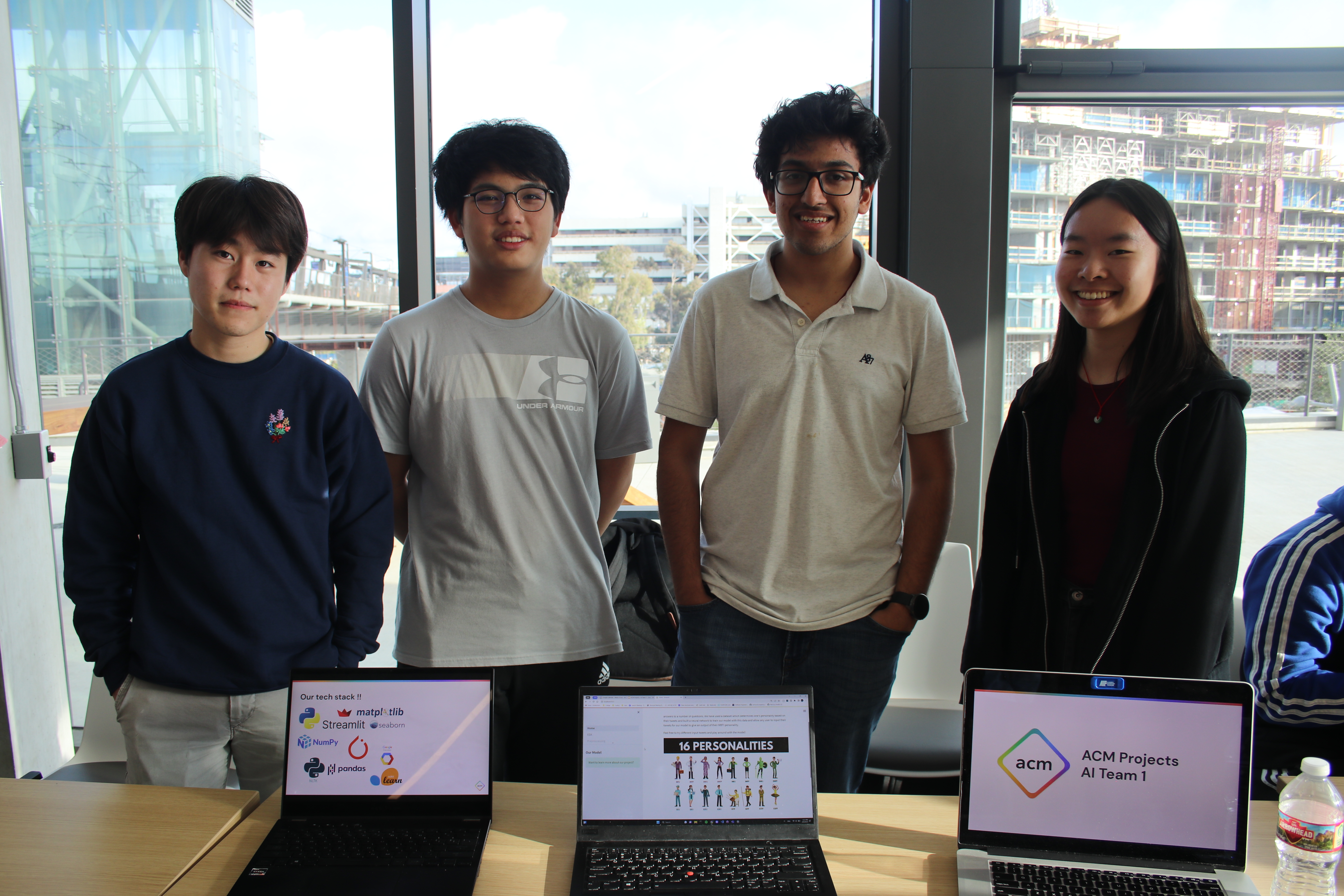 Four people standing in behind laptops for ACM AI Projects